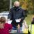 A man hands ballots to workers at a park table