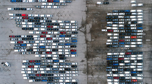 A bird's eye view of a parking lot filled with cars.