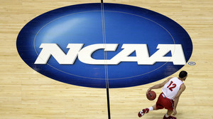 Wisconsin's Traevon Jackson dribbles past the NCAA logo