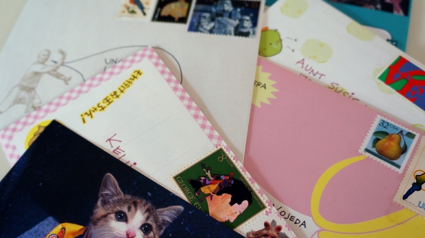 A pile of letters and postcards waiting to be mailed.