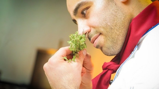 Male chef smelling herbs