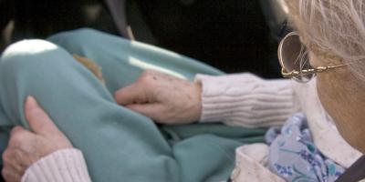 seated older White woman looking at hands seated older White woman looking at hands